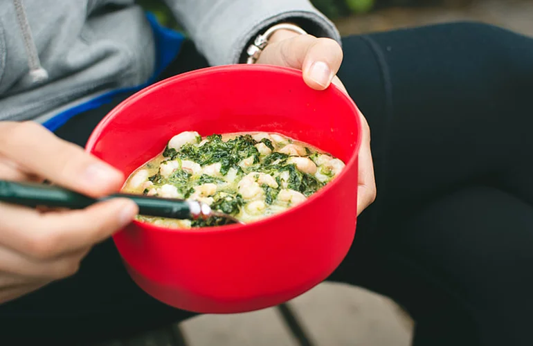 Photograph of a meal in a bright red bowl.
