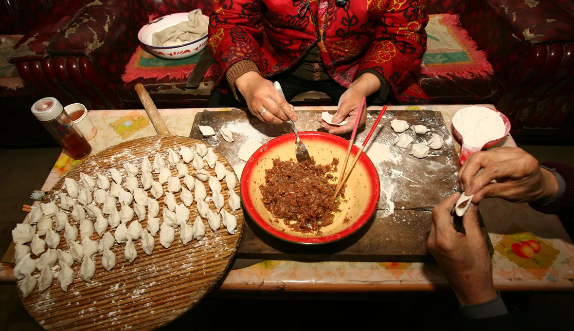 Family members make 'jiaozi' (Chinese dumplings stuffed with meat and/or vegetables) for dinner on the Chinese New Year's Eve in the village of Yangxi on February 17, 2007 in Fuxian County of Shaanxi Province, China.