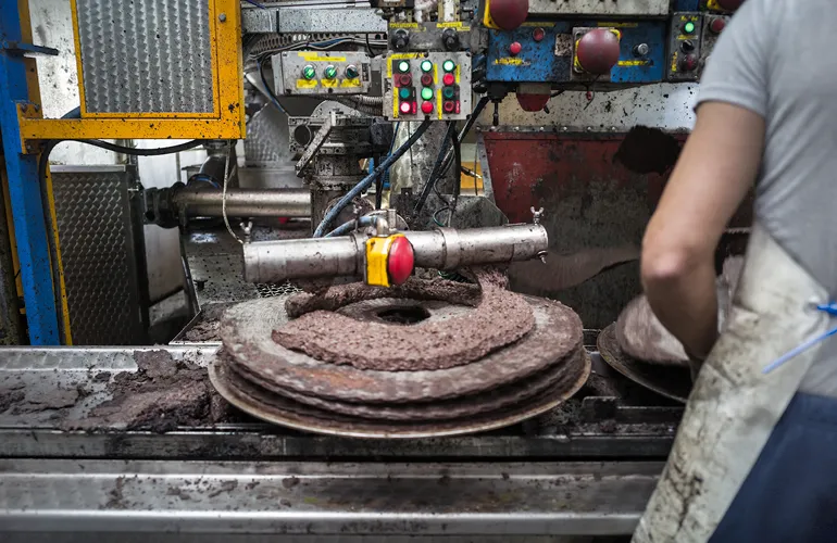 In the traditional mill, the pomace is then spread onto weaved disks that are stacked and squeezed under hydraulic presses to extract the raw oil.