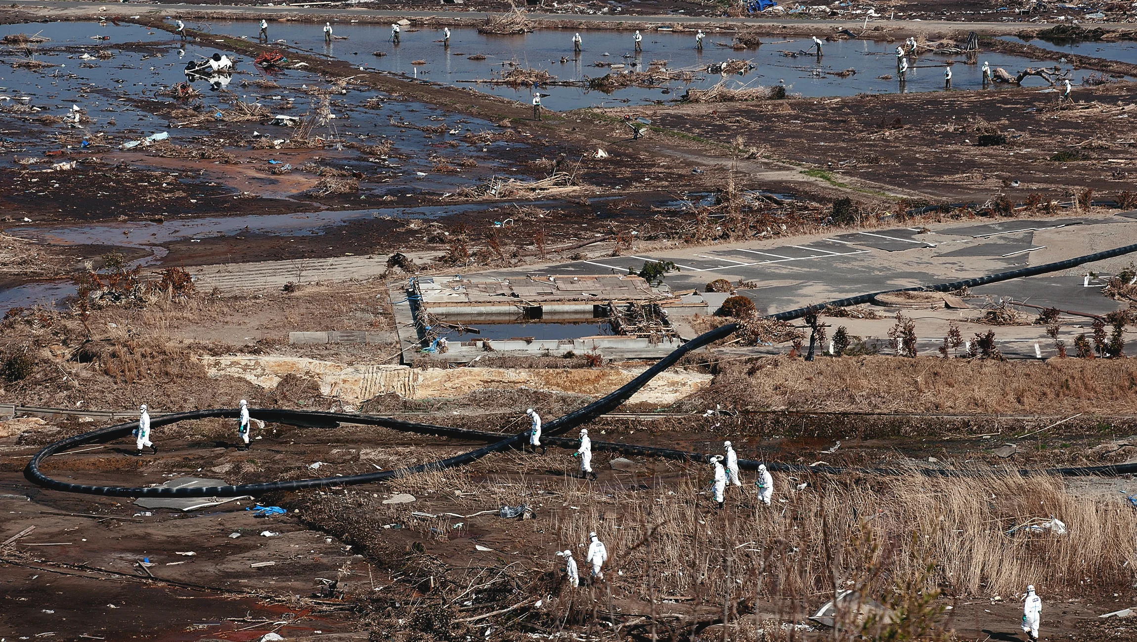 Police officers wearing radiation protective gears search the area surrounding Fukushima Nuclear Plant on April 15, 2011. Japan raised the nuclear accident severity level to 7, the highest level on the International Nuclear Event Scale and the same level a