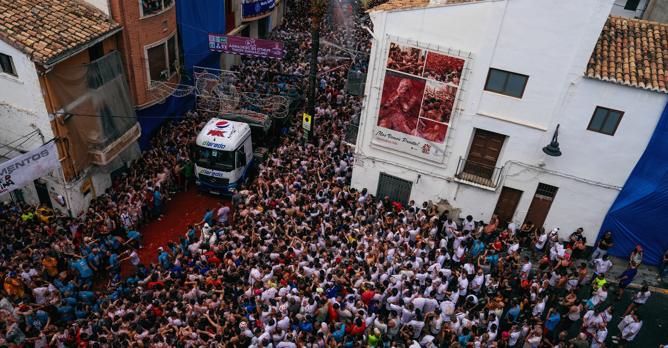 Revellers arrive at the town hall square in the back of a lorry containing tomatoes. (Photo by Zowy Voeten via Getty Images)